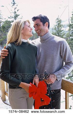 Stock Image - Young man holding a young woman. Fotosearch