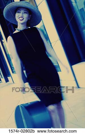 Stock Image - Young woman carrying a bag. Fotosearch