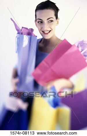 Stock Image - Young woman carrying shopping bags. Fotosearch