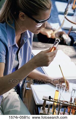 Young woman holding a test tube View Large Photo Image Stock Image - Young woman holding a test tube. Fotosearch
