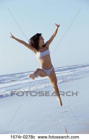 Young woman jumping at the beach View Large Photo Image Stock Image - Young woman jumping at the beach. Fotosearch