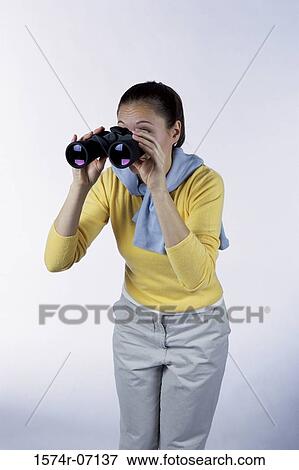 Young woman looking through binoculars View Large Photo Image Stock Photo - Young woman looking through binoculars. Fotosearch