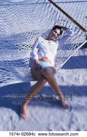 Young woman lying in a hammock View Large Photo Image Stock Image - Young woman lying in a hammock. Fotosearch