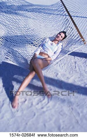 Young woman lying in a hammock View Large Photo Image Stock Image - Young woman lying in a hammock. Fotosearch