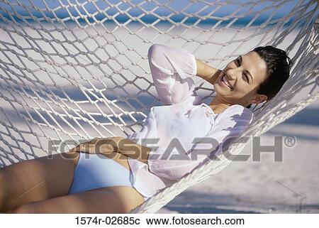 Young woman lying in a hammock View Large Photo Image Stock Image - Young woman lying in a hammock. Fotosearch
