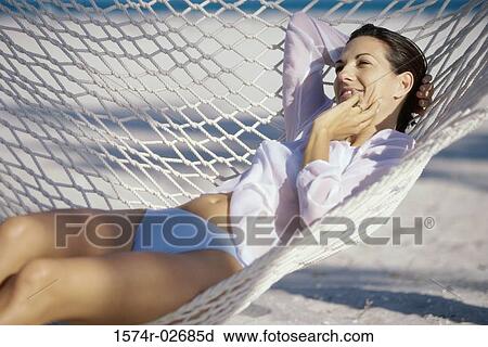 Stock Image - Young woman lying in a hammock. Fotosearch