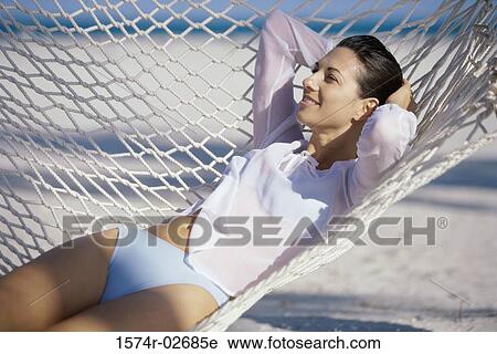 Young woman lying in a hammock View Large Photo Image Stock Image - Young woman lying in a hammock. Fotosearch