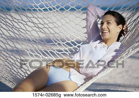 Stock Image - Young woman lying in a hammock. Fotosearch