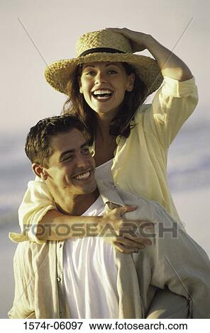 Young woman riding piggyback on a young man on the beach View Large Photo Image Stock Photo - Young woman riding piggyback on a young man on the beach. Fotosearch