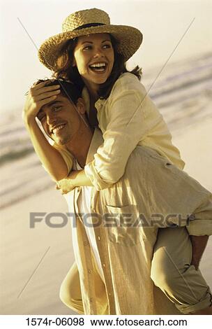 Young woman riding piggyback on a young man on the beach View Large Photo Image Stock Photo - Young woman riding piggyback on a young man on the beach. Fotosearch