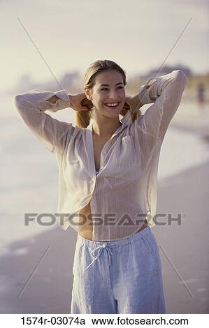 Young woman standing on the beach View Large Photo Image Stock Image - Young woman standing on the beach. Fotosearch