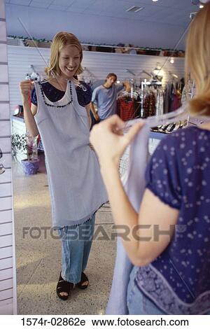 Young woman trying on clothes in a clothing store View Large Photo Image Stock Image - Young woman trying on clothes in a clothing store. Fotosearch