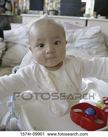 Baby eating in a walker View Large Photo Image Stock Image - Baby eating in a walker. Fotosearch