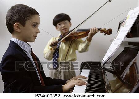 Boy playing the piano and another playing the violin View Large Photo Image Stock Image - Boy playing the piano and another playing the violin. Fotosearch