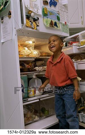 Boy standing in front of an open refrigerator View Large Photo Image Stock Image - Boy standing in front of an open refrigerator. Fotosearch