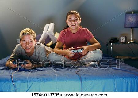 Brother and sister playing video games View Large Photo Image Stock Photograph - Brother and sister playing video games. Fotosearch