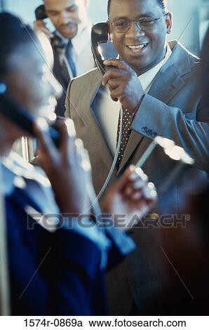 Business executives using pay phones View Large Photo Image Stock Image - Business executives using pay phones. Fotosearch