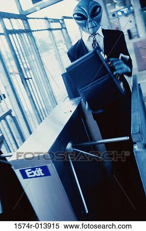 Businessman dressed up as an alien holding a briefcase View Large Photo Image Stock Photography - Businessman dressed up as an alien holding a briefcase. Fotosearch