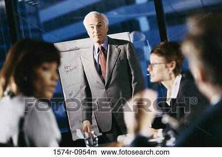 Businessman giving a presentation in a meeting View Large Photo Image Picture - Businessman giving a presentation in a meeting. Fotosearch