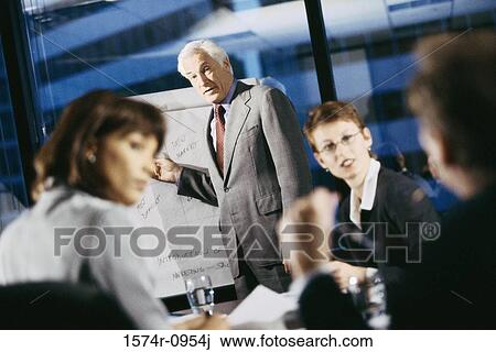 Businessman giving a presentation in a meeting View Large Photo Image Stock Image - Businessman giving a presentation in a meeting. Fotosearch