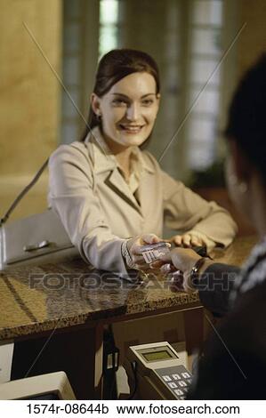 Businesswoman handing a credit card to a hotel clerk View Large Photo Image Stock Image - Businesswoman handing a credit card to a hotel clerk. Fotosearch
