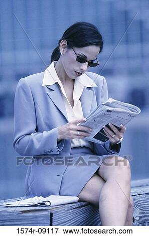Stock Photo - Businesswoman reading a newspaper. Fotosearch