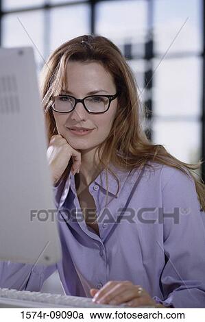 Stock Image - Businesswoman sitting in front of a computer monitor. Fotosearch