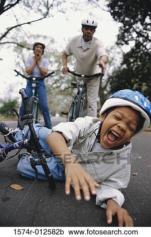 Close-up of a boy fallen off of a bicycle with his grandparents standing behind him View Large Photo Image Stock Image - Close-up of a boy fallen off of a bicycle with his grandparents standing behind him. Fotosearch