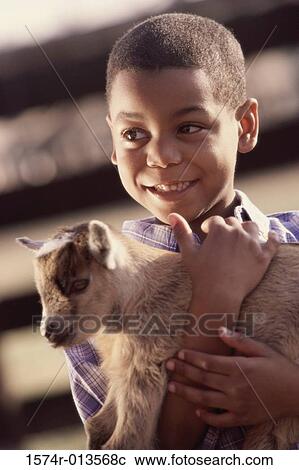 Close-up of a boy holding a lamb View Large Photo Image Stock Image - Close-up of a boy holding a lamb. Fotosearch