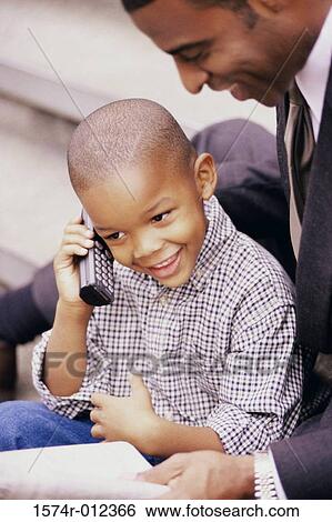 Close-up of a boy talking on a mobile phone View Large Photo Image Stock Photograph - Close-up of a boy talking on a mobile phone. Fotosearch