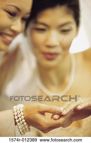 Stock Photo - Close-up of a bride showing her wedding ring to her mother. Fotosearch
