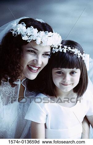 Stock Image - Close-up of a bride sitting with a flower girl. Fotosearch