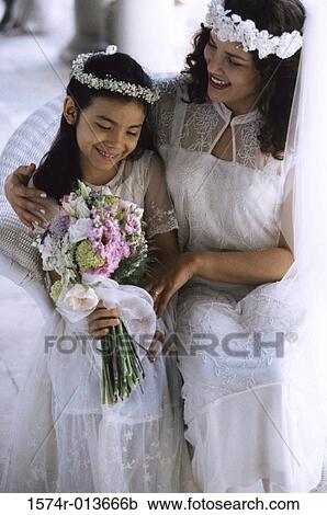 Close-up of a bride sitting with a flower girl View Large Photo Image Stock Image - Close-up of a bride sitting with a flower girl. Fotosearch
