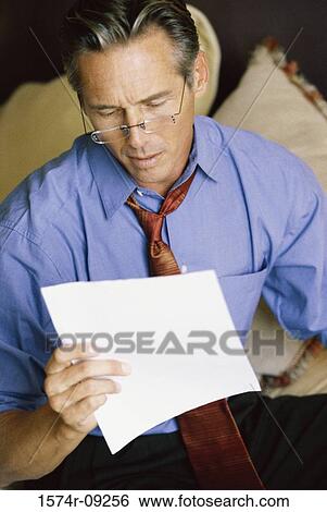 Stock Photograph - Close-up of a businessman reading a sheet of paper. Fotosearch