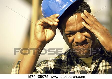 Close-up of a construction worker touching his head and removing his hardhat View Large Photo Image Stock Photography - Close-up of a construction worker touching his head and removing his hardhat. Fotosearch