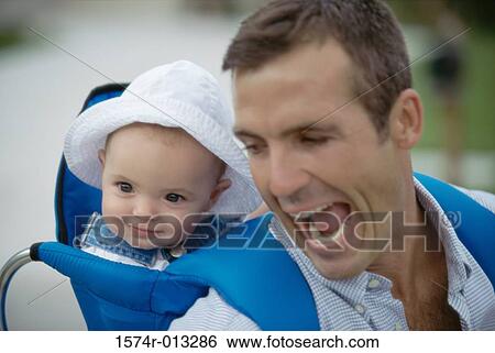 Close-up of a father carrying his son on his back View Large Photo Image Stock Photograph - Close-up of a father carrying his son on his back. Fotosearch
