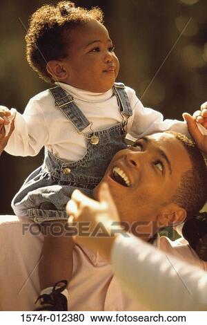 Close-up of a father carrying his daughter on his shoulders View Large Photo Image Stock Image - Close-up of a father carrying his daughter on his shoulders. Fotosearch