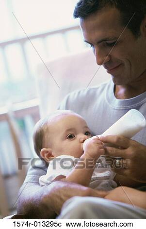 Stock Image - Close-up of a father feeding his son. Fotosearch