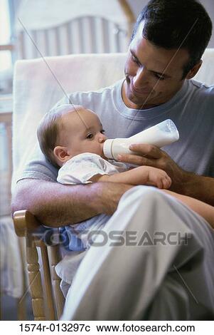 Stock Image - Close-up of a father feeding his son. Fotosearch