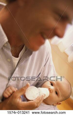 Stock Image - Close-up of a father feeding his daughter. Fotosearch
