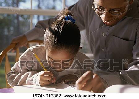 Close-up of a father helping his daughter with her homework View Large Photo Image Stock Image - Close-up of a father helping his daughter with her homework. Fotosearch