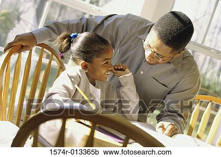 Close-up of a father helping his daughter with her homework View Large Photo Image Stock Image - Close-up of a father helping his daughter with her homework. Fotosearch