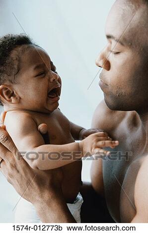Stock Image - Close-up of a father holding his son. Fotosearch