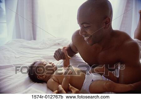 Stock Image - Close-up of a father playing with his son. Fotosearch
