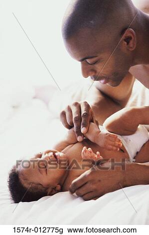 Close-up of a father playing with his son View Large Photo Image Stock Image - Close-up of a father playing with his son. Fotosearch