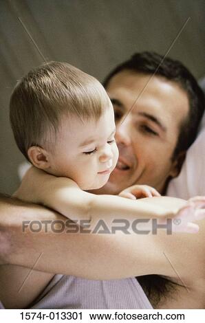 Stock Image - Close-up of a father playing with his daughter. Fotosearch