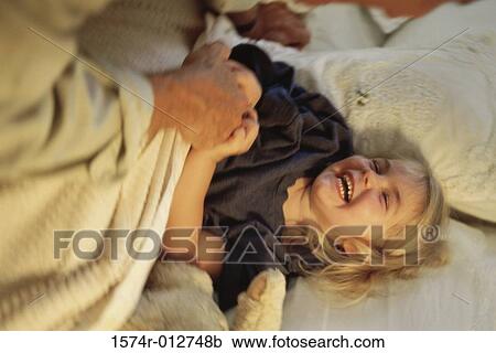 Close-up of a girl playing with her father on the bed View Large Photo Image Stock Image - Close-up of a girl playing with her father on the bed. Fotosearch