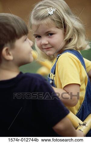 Close-up of a girl sitting with a boy View Large Photo Image Stock Image - Close-up of a girl sitting with a boy. Fotosearch
