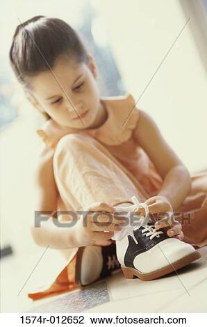 Close-up of a girl tying her shoelaces View Large Photo Image Stock Image - Close-up of a girl tying her shoelaces. Fotosearch