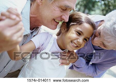 Stock Image - Close-up of a granddaughter and her grandparents smiling. Fotosearch